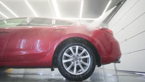 lavado de automóviles limpieza con espuma y agua a alta presión. coche rojo
