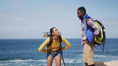 una pareja afroamericana se da los cinco mientras hacen trekking.