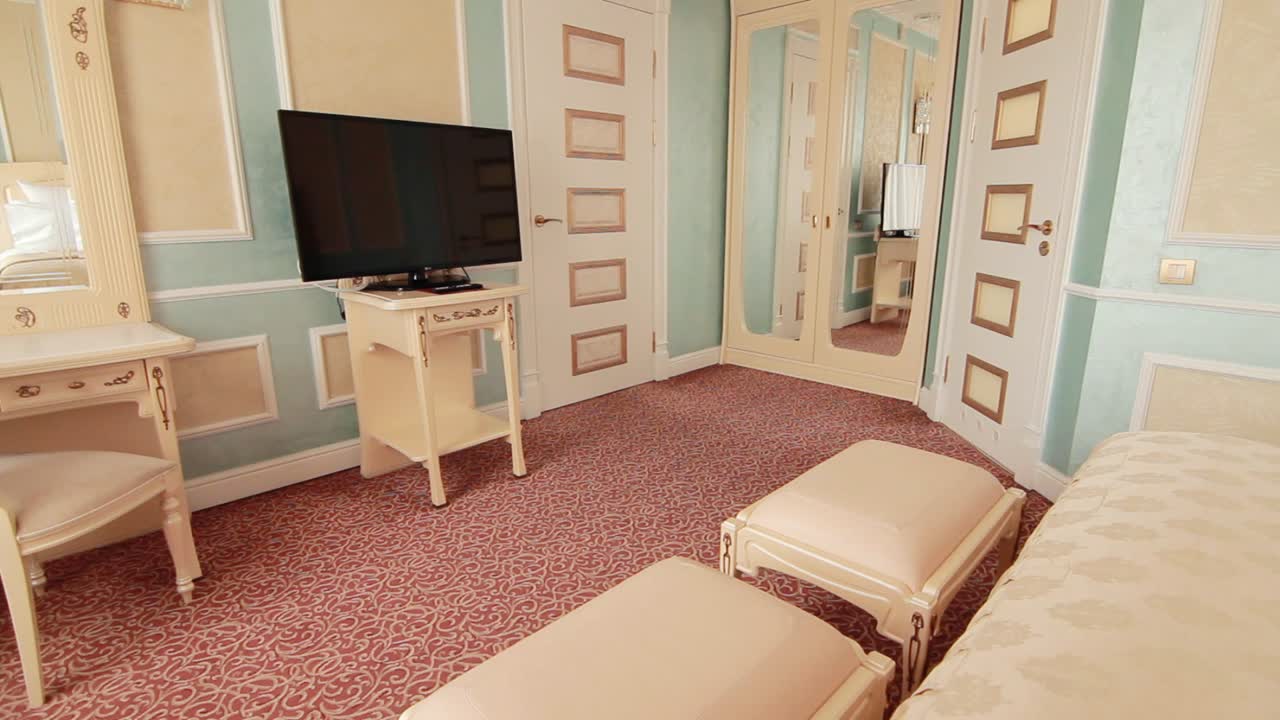 현대 호텔의 아파트에 벽에 플라즈마 tv와 함께 클래식 인테리어 침실