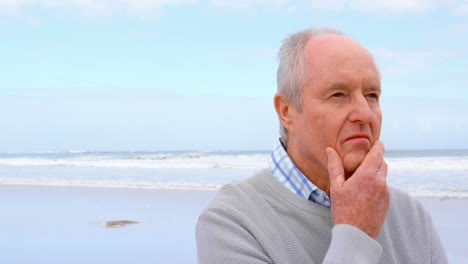 Front-view-of-old-caucasian-senior-man-standing-at-beach-4k