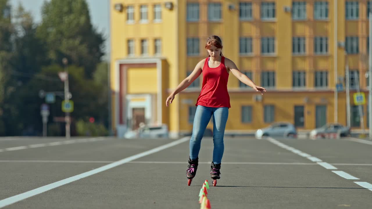 Pretty girl athlete makes rotations around herself on roller skates and goes around the cones, professional roller sports. Roller skating training outdoors. 4k, 10bit, ProRes