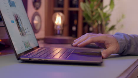 la mano del hombre navegando y desplazándose por las redes sociales a través de una computadora portátil.