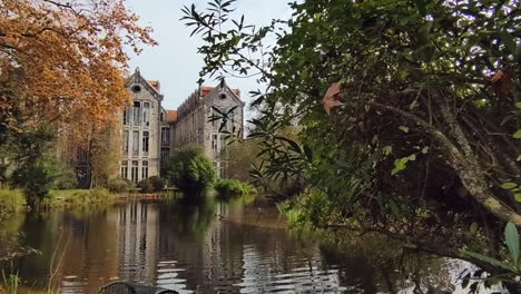 Tagsüber-Blick-Auf-Den-Ruhigen-See-Und-Das-Alte-Gebäude---Dom-Carlos-I-Park-In-Caldas-Da-Rainha---Zeitlupen-schieberaufnahme