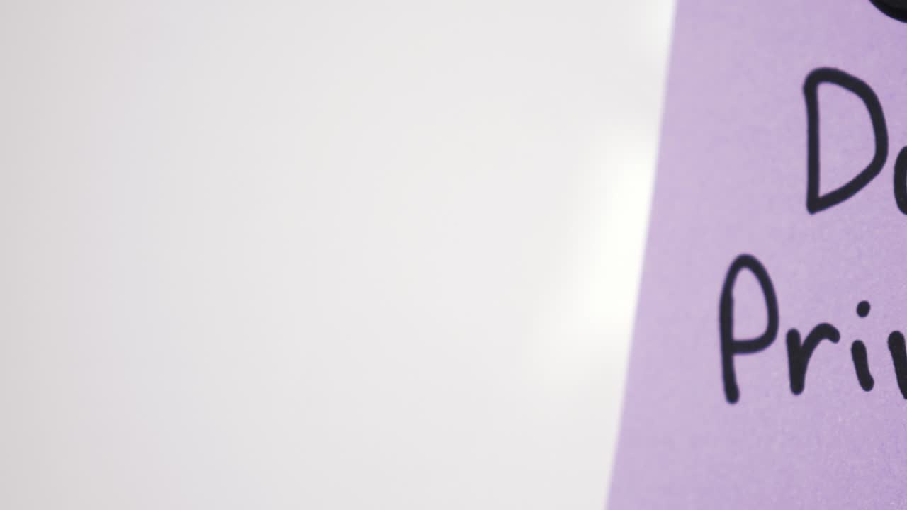 Inquadratura panoramica del testo sulla privacy dei dati su un foglietto viola tenuto da un magnete su una lavagna bianca con messa a fuoco selettiva