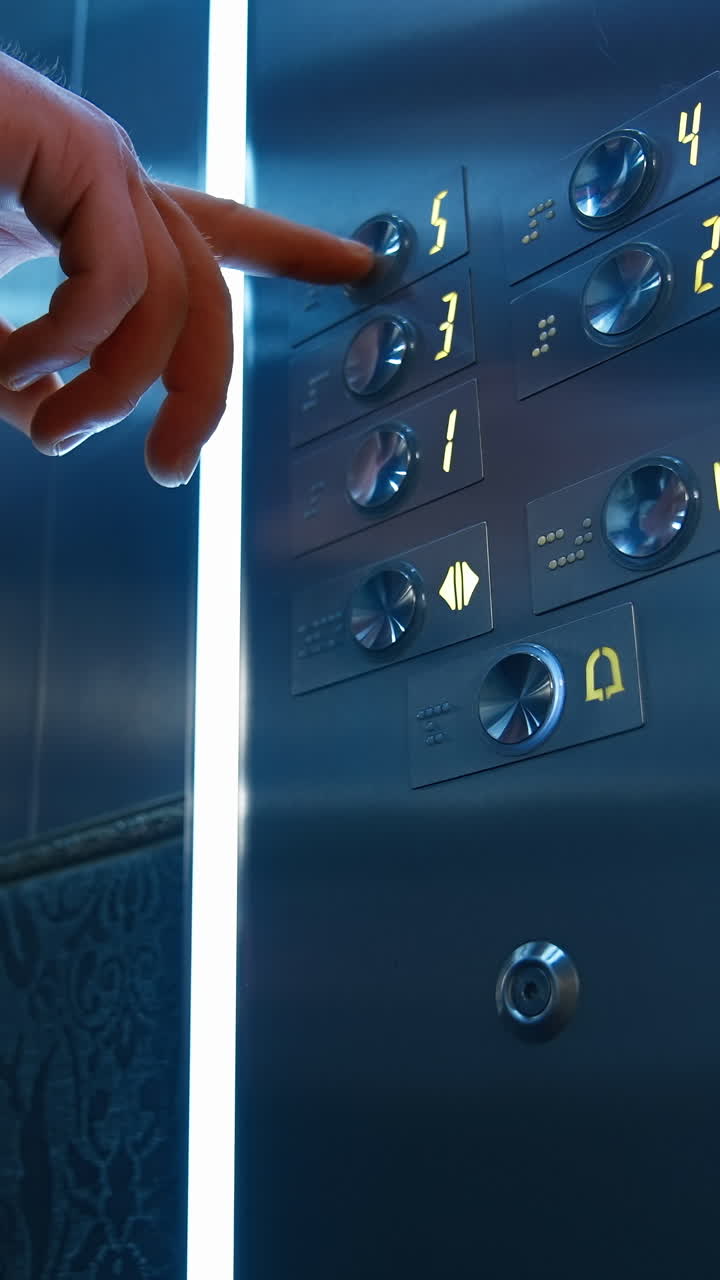 Man`s hand presses floor buttons in elevator. Unrecognizible man in suit pushes floor button. Selective focus. Vertical video