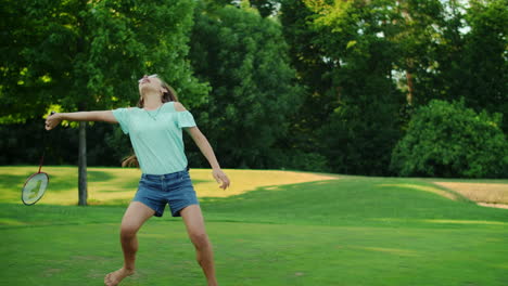 Mädchen-Hält-Badmintonschläger-In-Der-Hand.-Lächelnder-Teenager,-Der-Badminton-Im-Park-Spielt