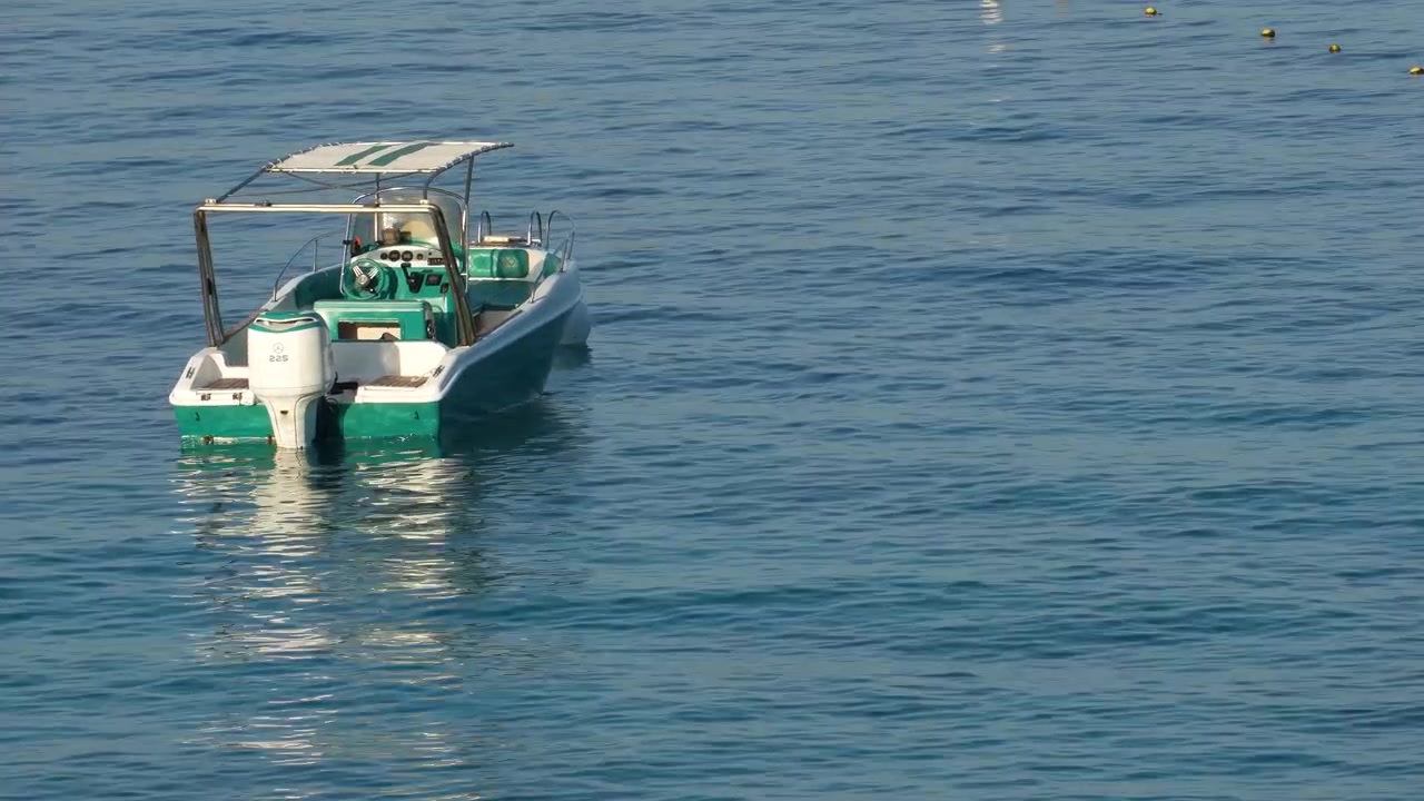 Barca a vela isolata ancorata su un mare calmo al mattino, nel blu del Mediterraneo
