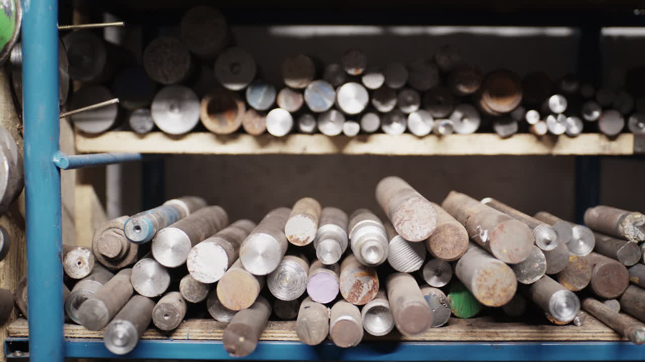 Officina di lavorazione metalli industriale con scaffali di stoccaggio di tubi di acciaio grezzo, barre piene e strumenti di misurazione di precisione