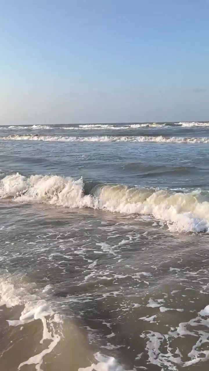 Dolci onde dell'oceano che si infrangono su una spiaggia sabbiosa.