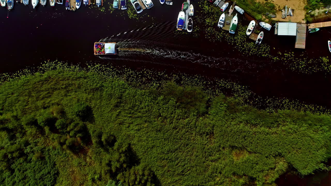 녹색 초목이 있는 습지를 지나가는 리루페 강에서 보트 순항의 머리 위 전망