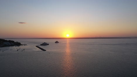 Aerial-shot-showing-a-low-sun-about-to-send-on-the-horizon,-shot-on-a-calm-clear-sky-day