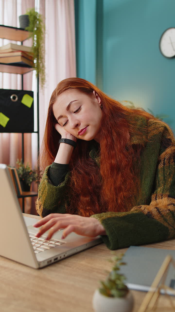 Bored sleepy business woman worker working on laptop computer yawns leaning on hand at office desk