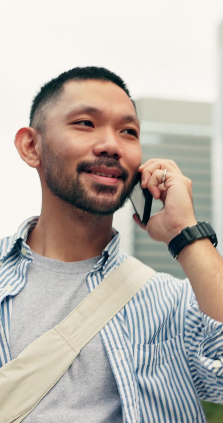 Young Asian Man Talking on Smartphone in Urban Setting