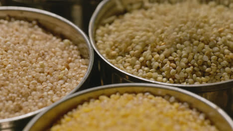 filling brown top millet in steel bowl with foxtail millet and little millet for storage, 4k, stable shot