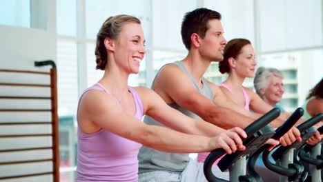 Happy-fitness-group-doing-a-spinning-class