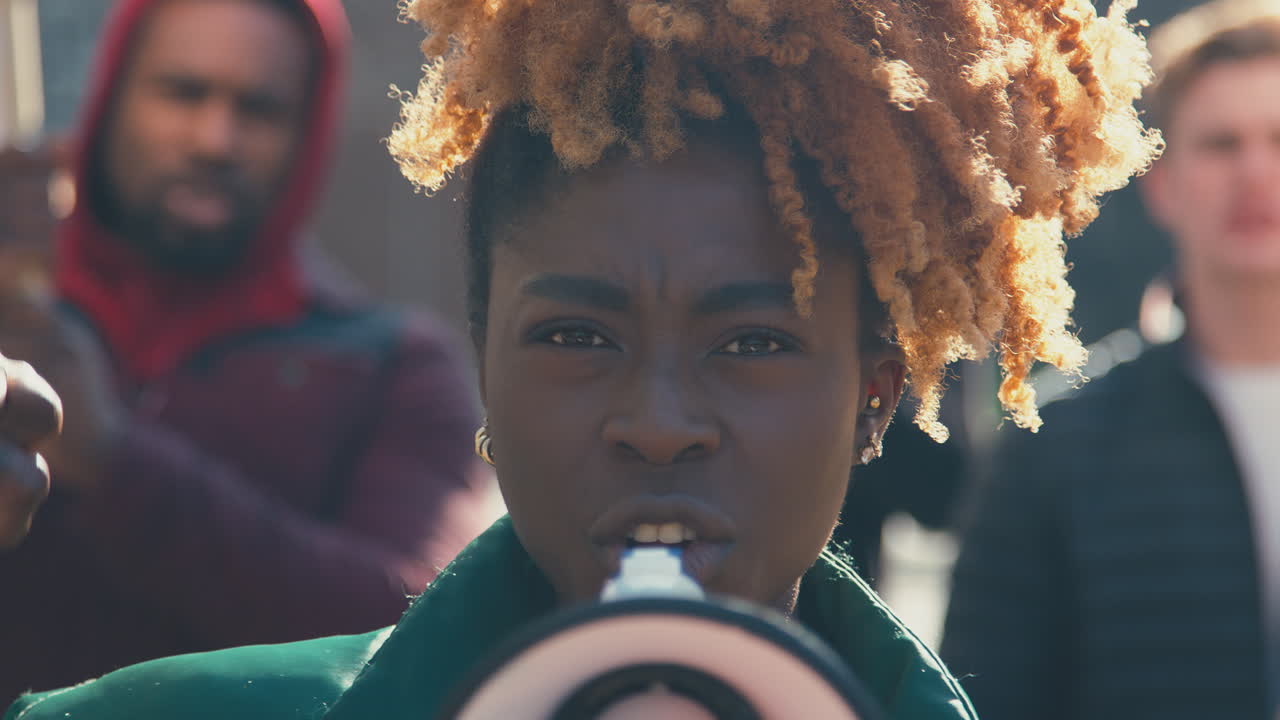 기후 변화에 반대하는 시위 행진에서 플래카드와 메가폰을 들고 있는 시위대