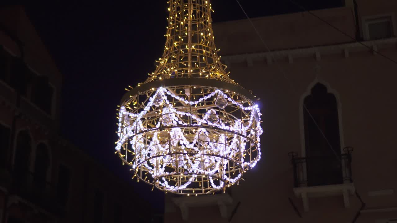 An outdoor chandelier illuminated at night
