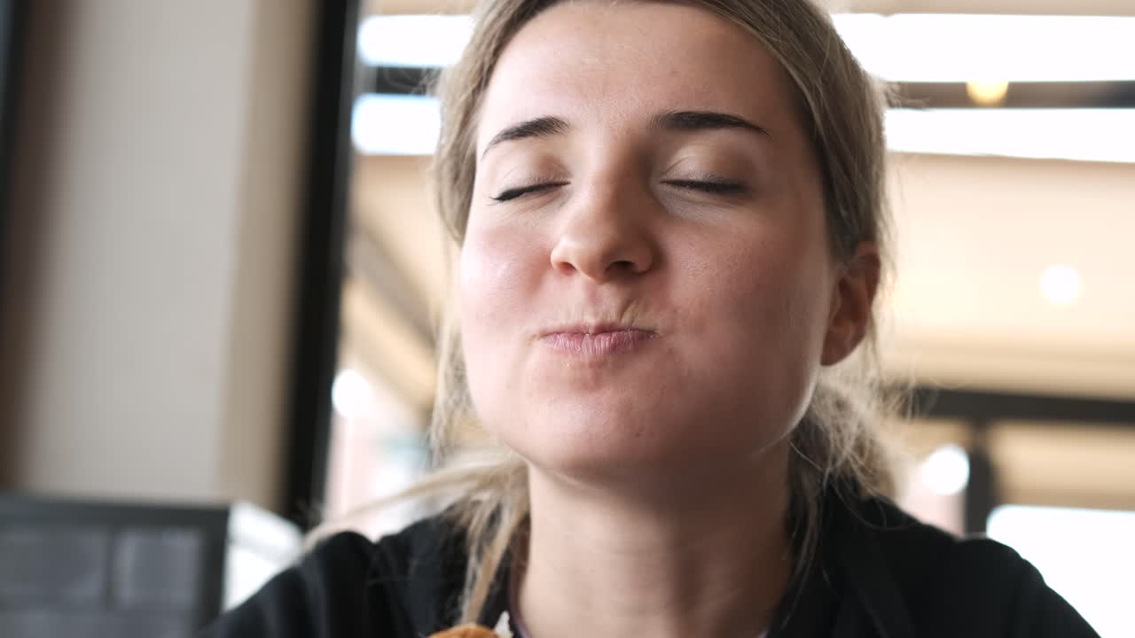 Young woman relishing every bite of a juicy burger in a cozy restaurant setting