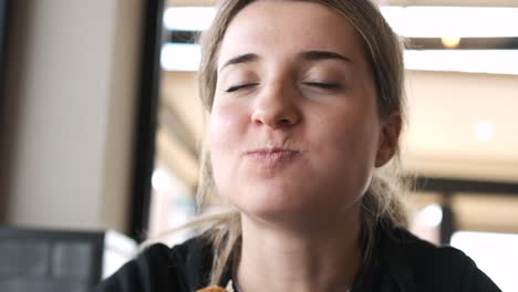 young woman relishing every bite of a juicy burger in a cozy restaurant setting
