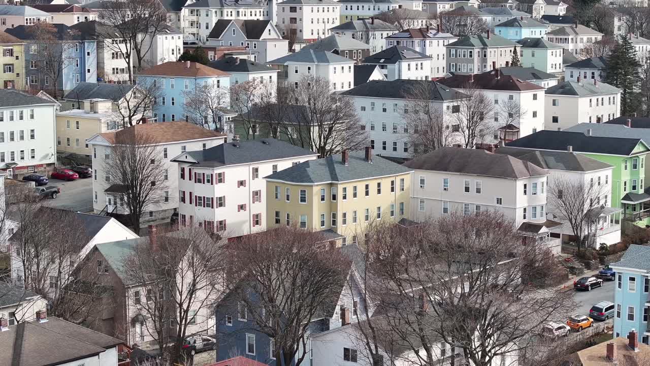 Triple Decker houses in Worcester, Massachusetts. Tight zoom aerial establishing shot of urban housing in New England during winter.