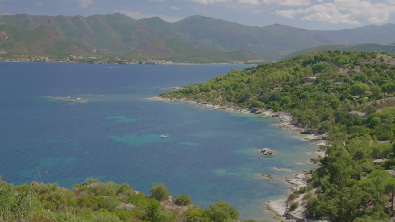 Saint-Florent Corsica coast sunny panorama view of crystal clear turquoise water, rocky shorelines under a bright blue sky serene untouched natural beauty northern Corsican seaside