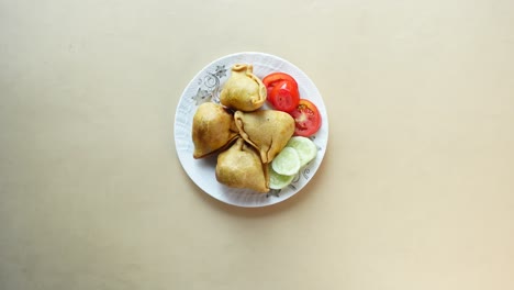 indian samosa snack with tomato and cucumber