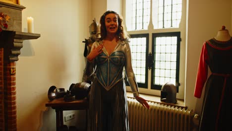 mujer atractiva vestida como una princesa guerrera de fantasía haciendo una presentación en una armería medieval