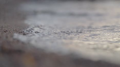 waves washing up the shore on sunset