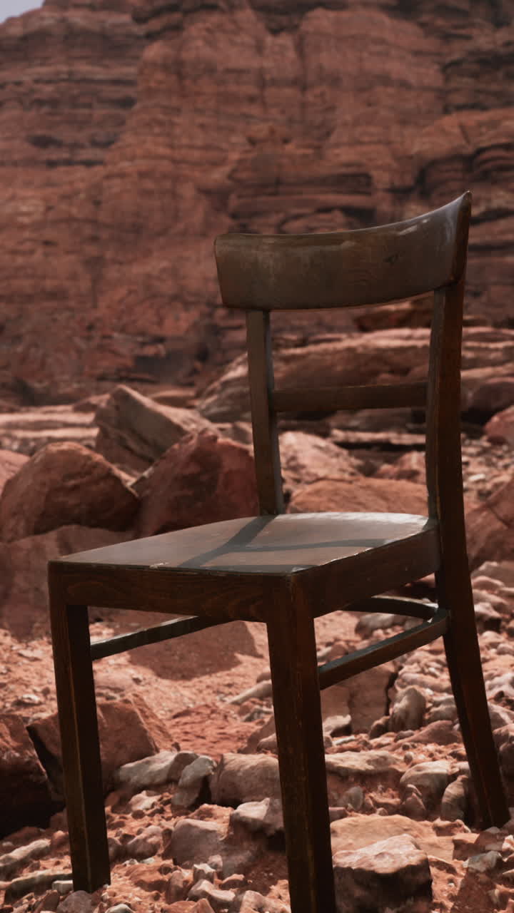 una silla de madera solitaria se sienta en un paisaje desértico de roca roja