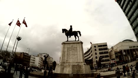 memorial of ataturk on horse  square turkish flags passersby pigeons cloudy day ankara
