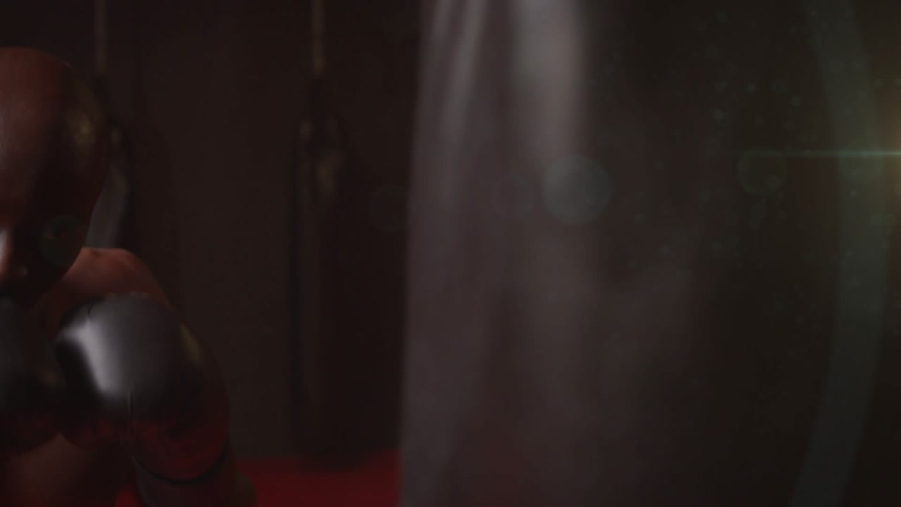 Male boxer approaching heavy bag, starting combos for training in boxing gym, blur showing speed