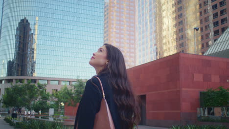 Brunette-woman-exploring-cityscape.-Asian-girl-looking-up-on-high-buildings.