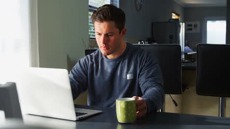 hombre discapacitado tomando café mientras usa portátil 4k