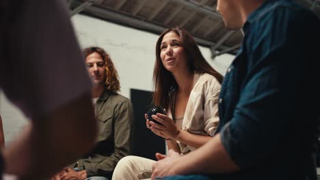 participants in group therapy pass each other a black ball and express their point of view about the problem in a white brick hall