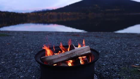 fuego de campamento montaña costa del lago en el crepúsculo