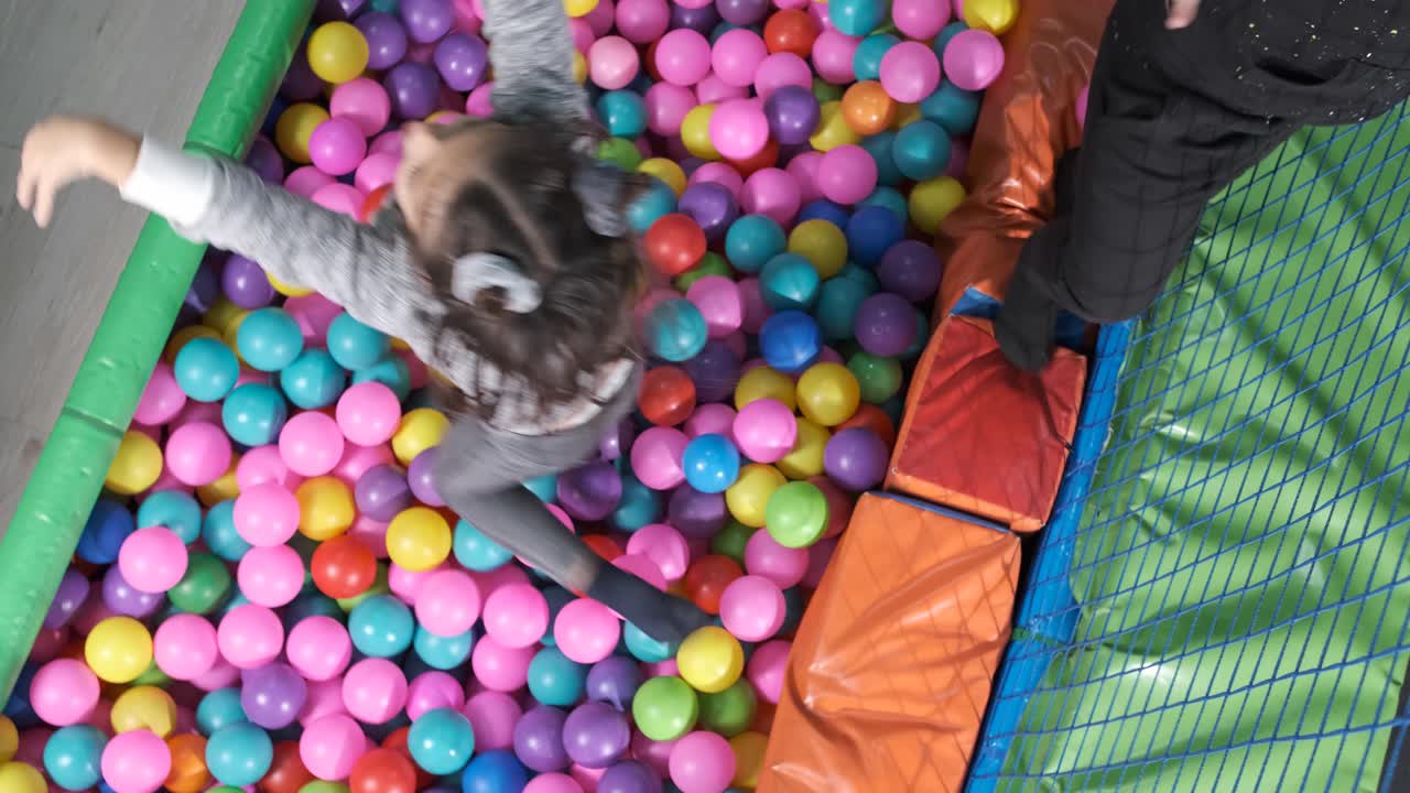 Happy children playing together and having fun at kindergarten with colorful balls. 5-6 years old