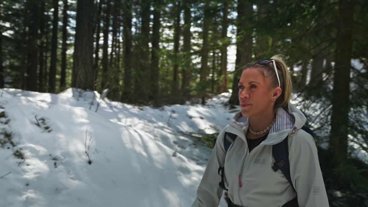 Portrait of a blonde caucasian adult woman walking in snowy forest