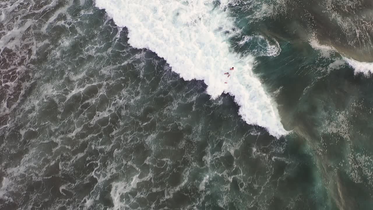 A surfer riding the waves of Bali, Indonesia - slow motion