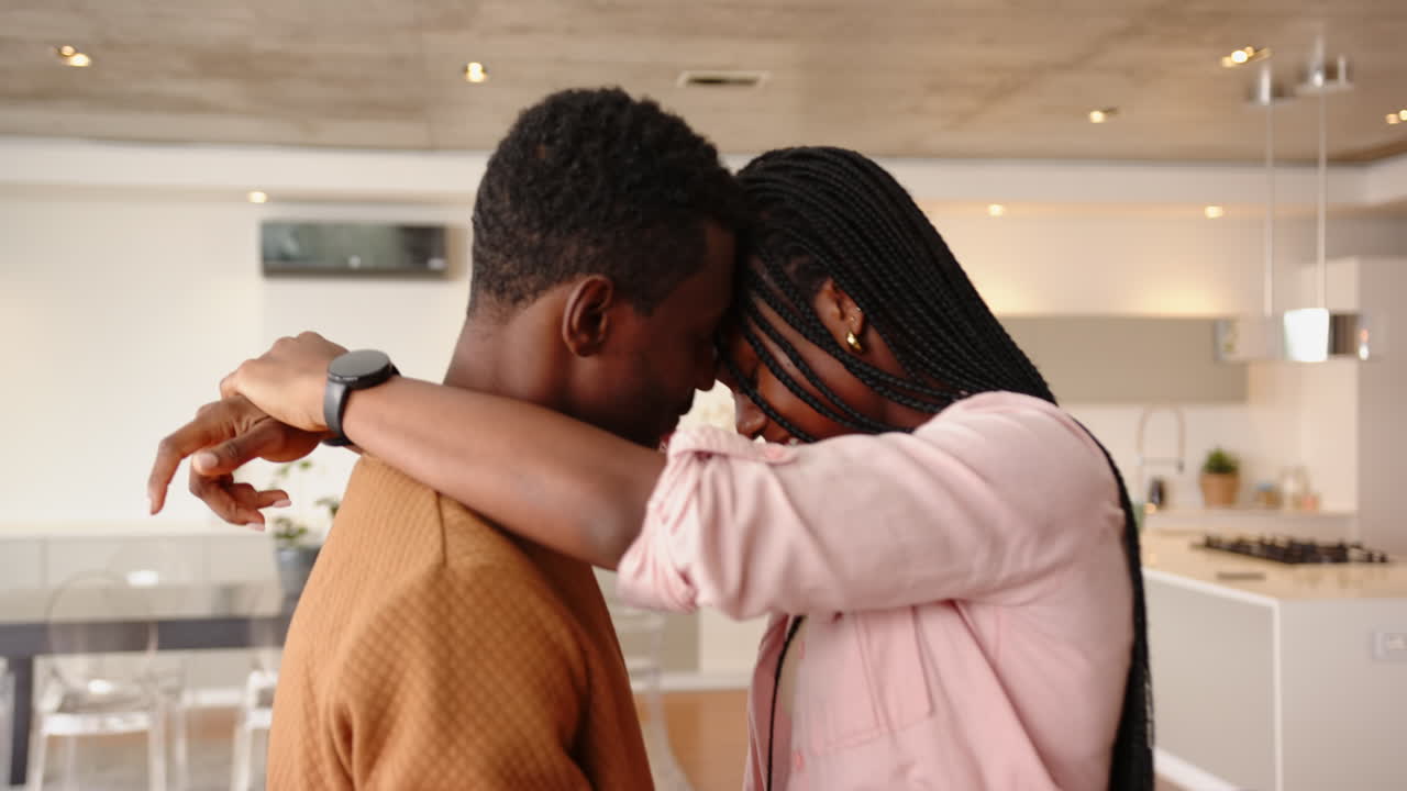 Embracing closely, young african american couple sharing intimate moment in cozy home setting