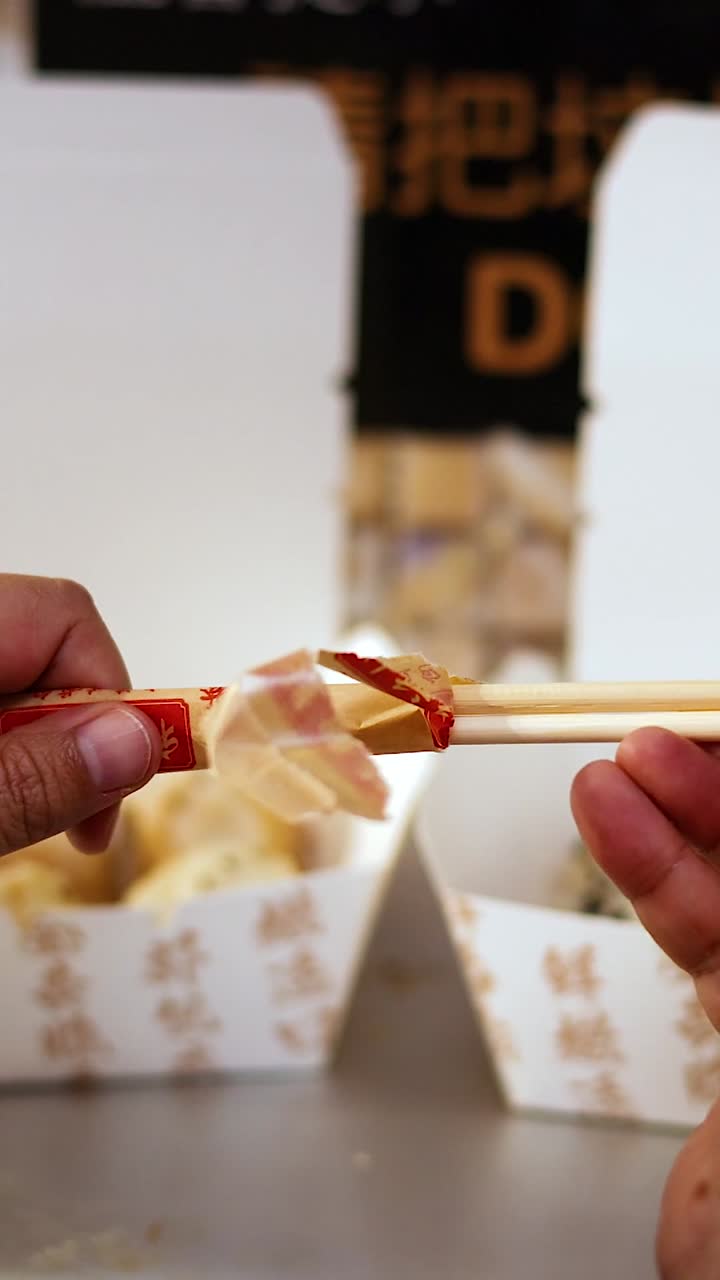 Hands preparing chopsticks for a meal