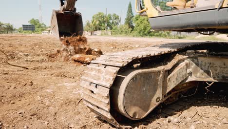 vista de ángulo bajo de un operador irreconocible en una excavadora amarilla excavando en un sitio de construcción