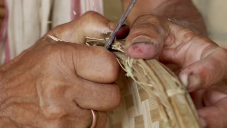 artesano artesano masculino que usa un cuchillo afilado para dar forma a un producto hecho a mano de bambú