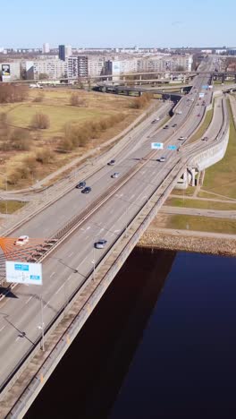 vertical bird's-eye drone shot flying over southern bridge traffic, riga