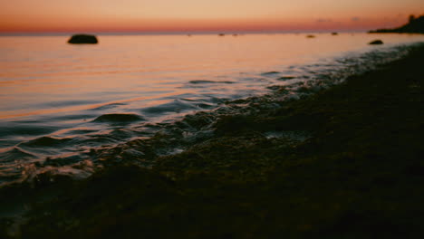 cinematic shot of ocean water meeting shore with beautiful sky at horizon in the background, slow motion