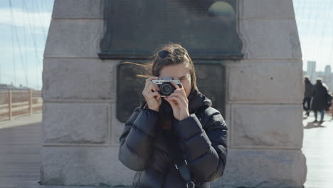 woman taking photos on brooklyn bridge