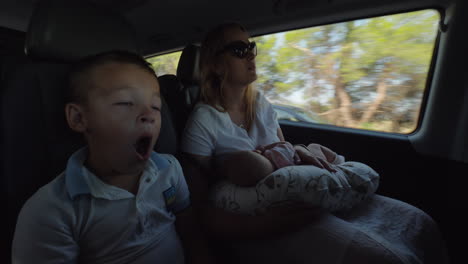 Madre-Con-Bebé-E-Hijo-Mayor-Viajando-En-Coche-Chico-Cansado-Y-Bostezando