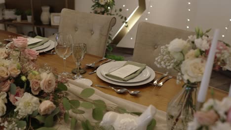 elegant dinner table with flowers candles and neutral pastel palette