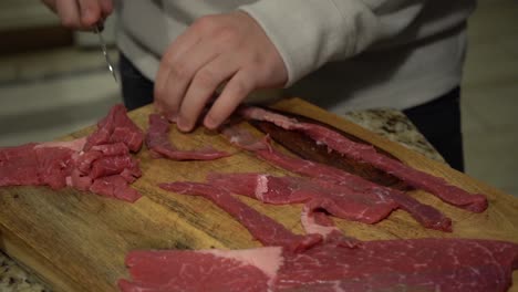 slicing steak on a cutting board in slow motion.