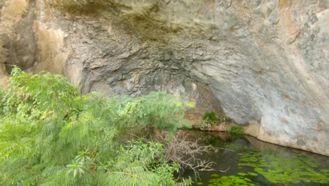 un pequeño lago enclavado en el lado de una cueva de una gran colina de granito en las zonas rurales de áfrica oriental