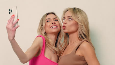 dos mujeres rubias tomando una selfie